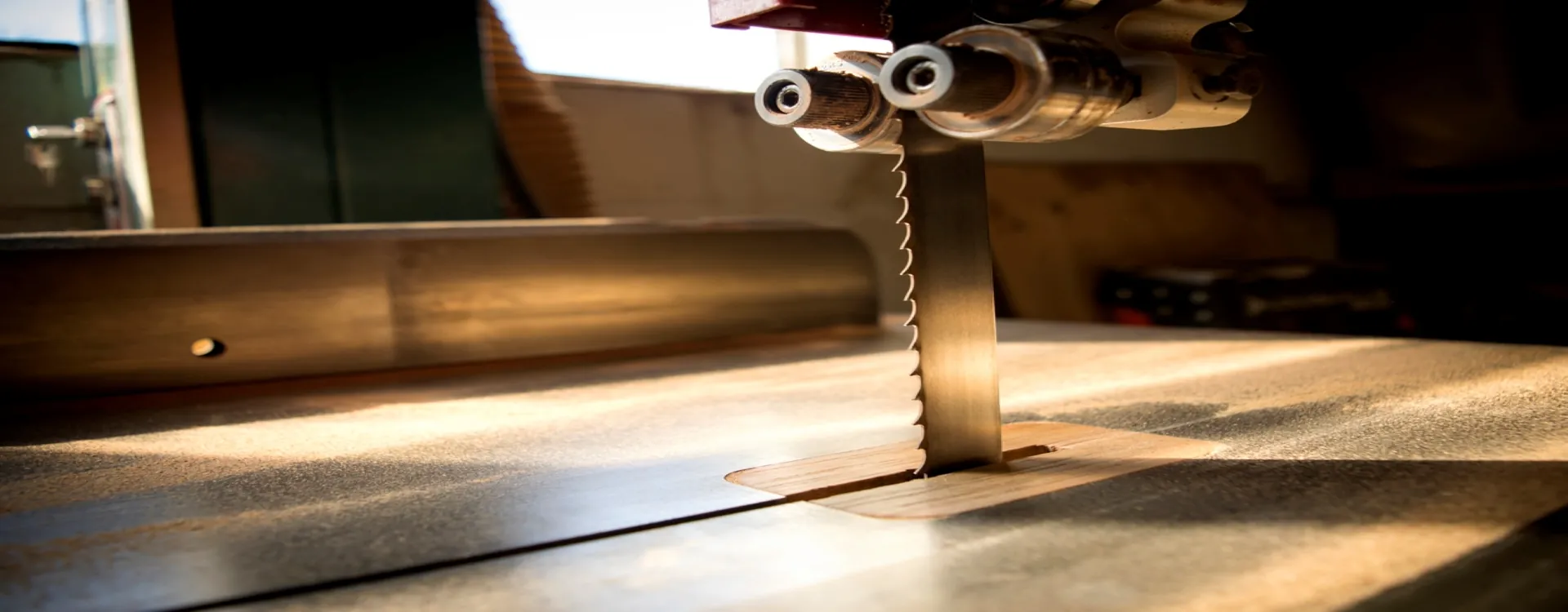 Close-up of a SawMaster bandsaw blade — part of our carbon and bimetal bandsaw blades range, made in the UK — cutting through a wooden workpiece
